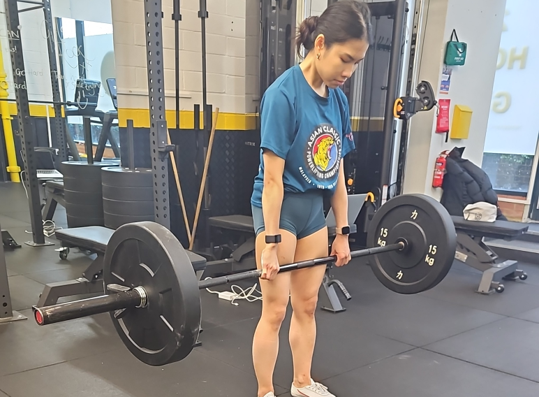 Girl with blue shirt lifting weight